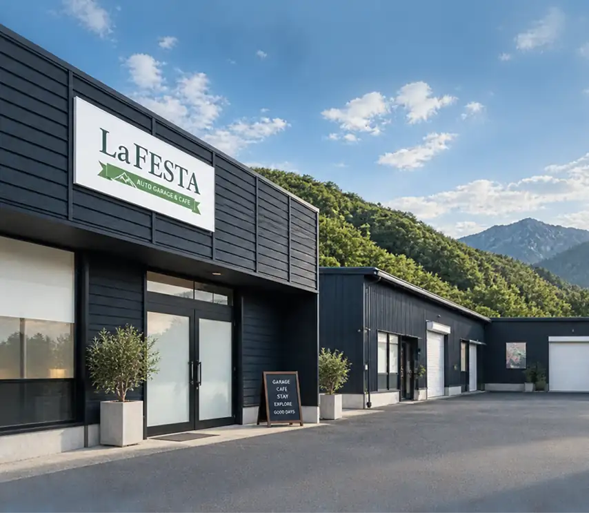 La.FESTA の看板を掲げた紺色の建物と、奥に並ぶガレージ